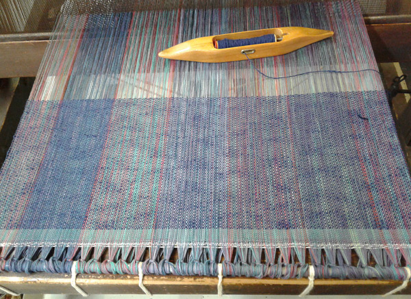 Warp tied to cloth beam apron, weaving begun